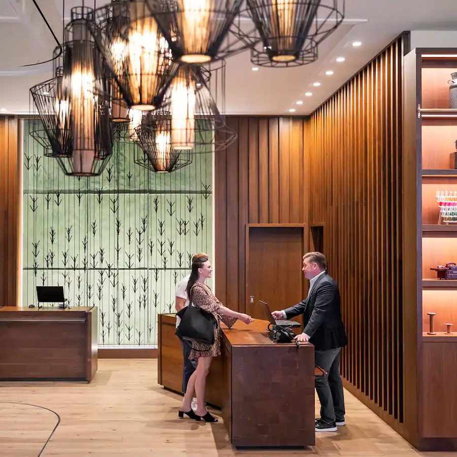 A couple stands at a reception desk at the Hyatt Centric Center City in Philadelphia.
