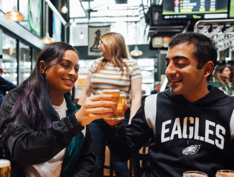 Two people toast with tiny beers at Yards Brewing Company in Philadelphia