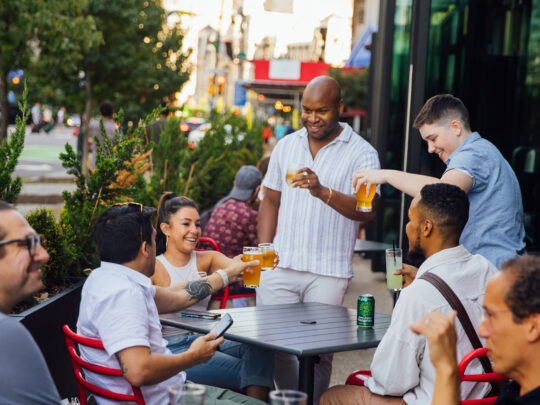 A group of friendstoasts at an outdoor table at Victory Brewing Company in Philadelphia