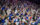 A large crowd cheering with their arms in the air at the end of a 76ers game