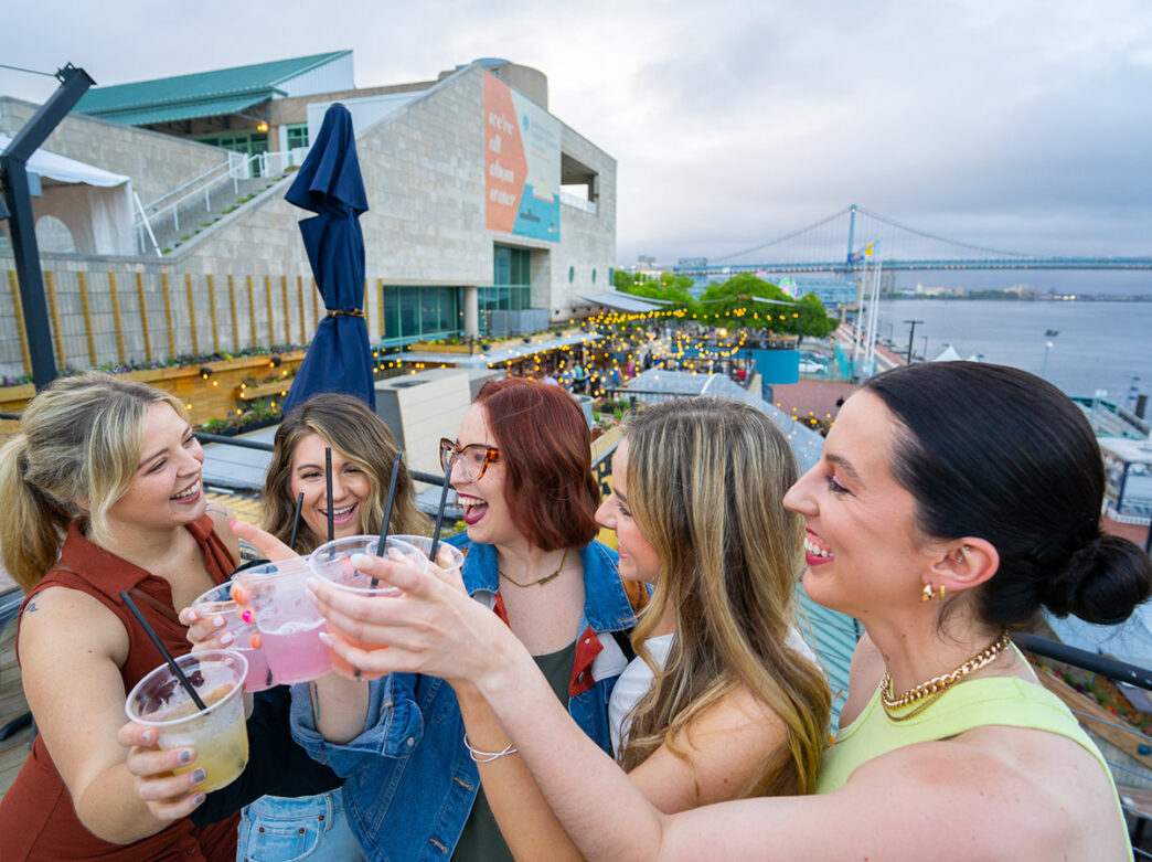 Un groupe de personnes à Liberty Point trinque avec la rivière Delaware en arrière-plan.