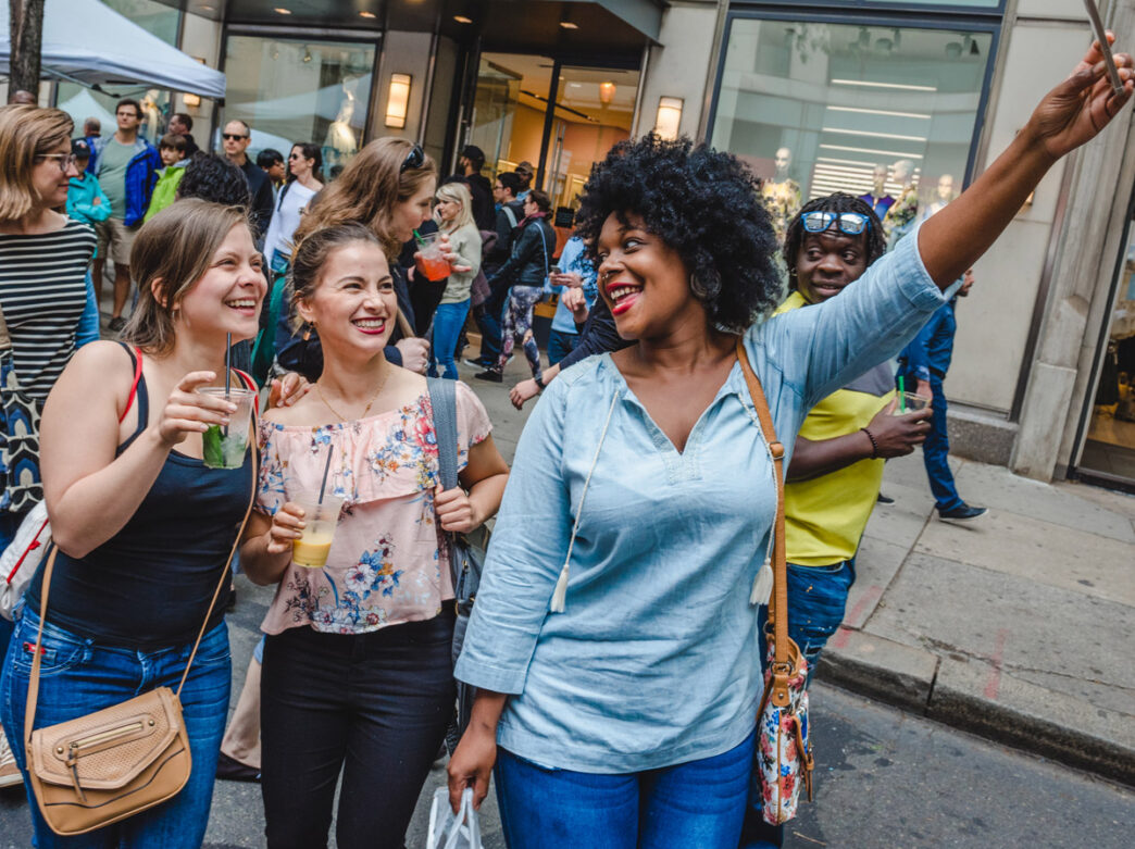Three women take a selfie during the Rittenhouse Row Spring Festival in Philadelphia