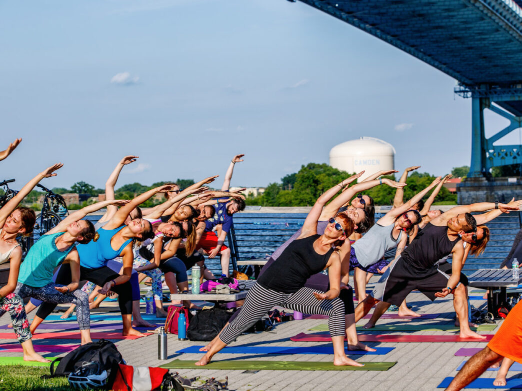Des gens pratiquant le yoga à Race Street Pier