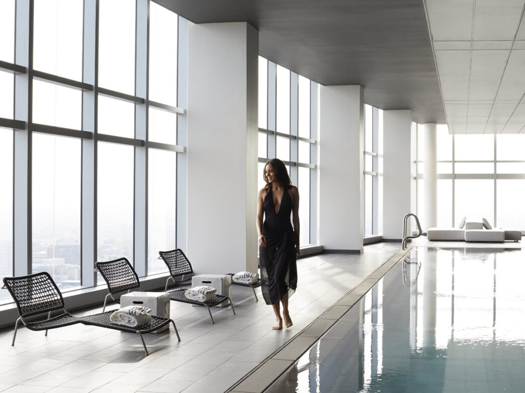 Mujer caminando por la piscina en AKA University City