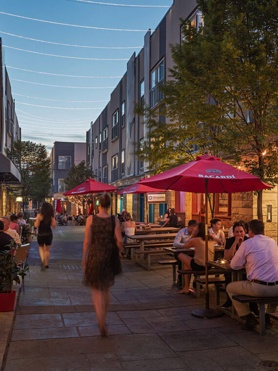 A person walks among outdoor tables at The Piazza in Philly's Northern Liberties neighbrohood