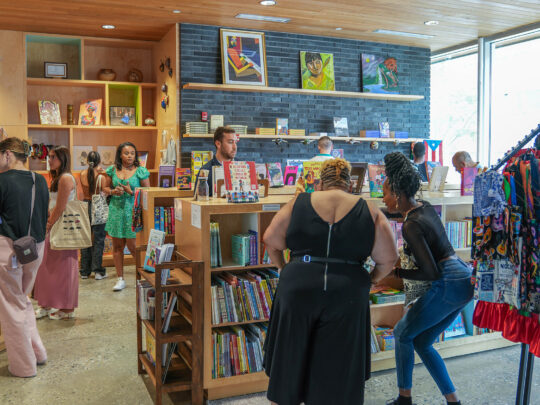 Group browsing books at Julia de Burgos Bookstore at Taller Puertorriqueño.