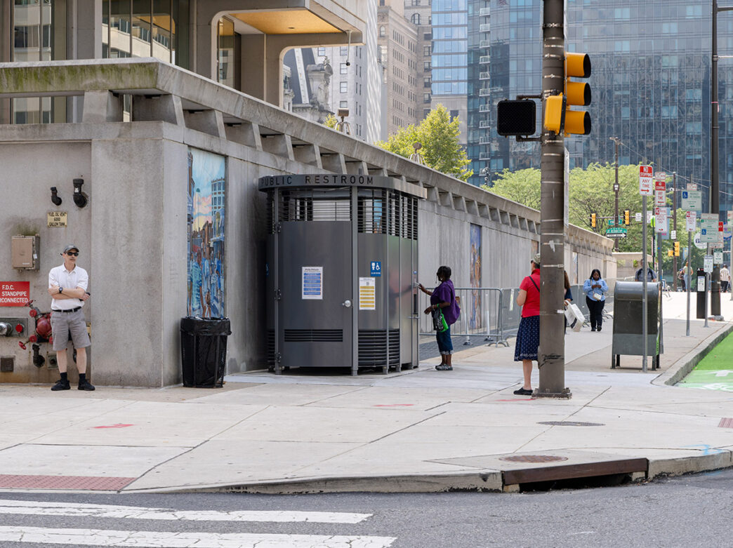 A gray box - the home of the Philly Phlush public restroom - sits on a gray sidewalk in Philadelphia