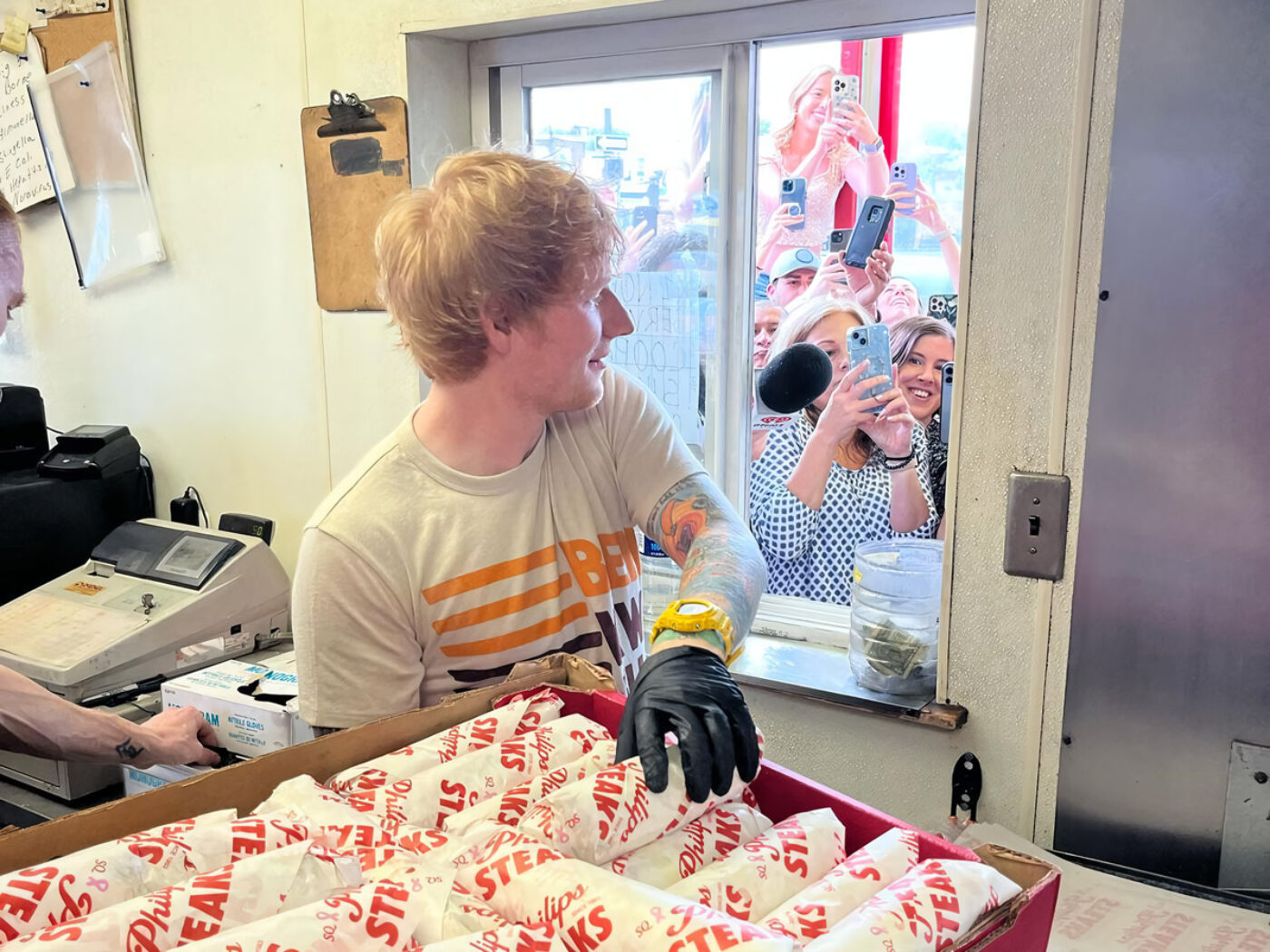 Ed Sheeran repartiendo cheesesteaks en SQ Philip's Steaks.