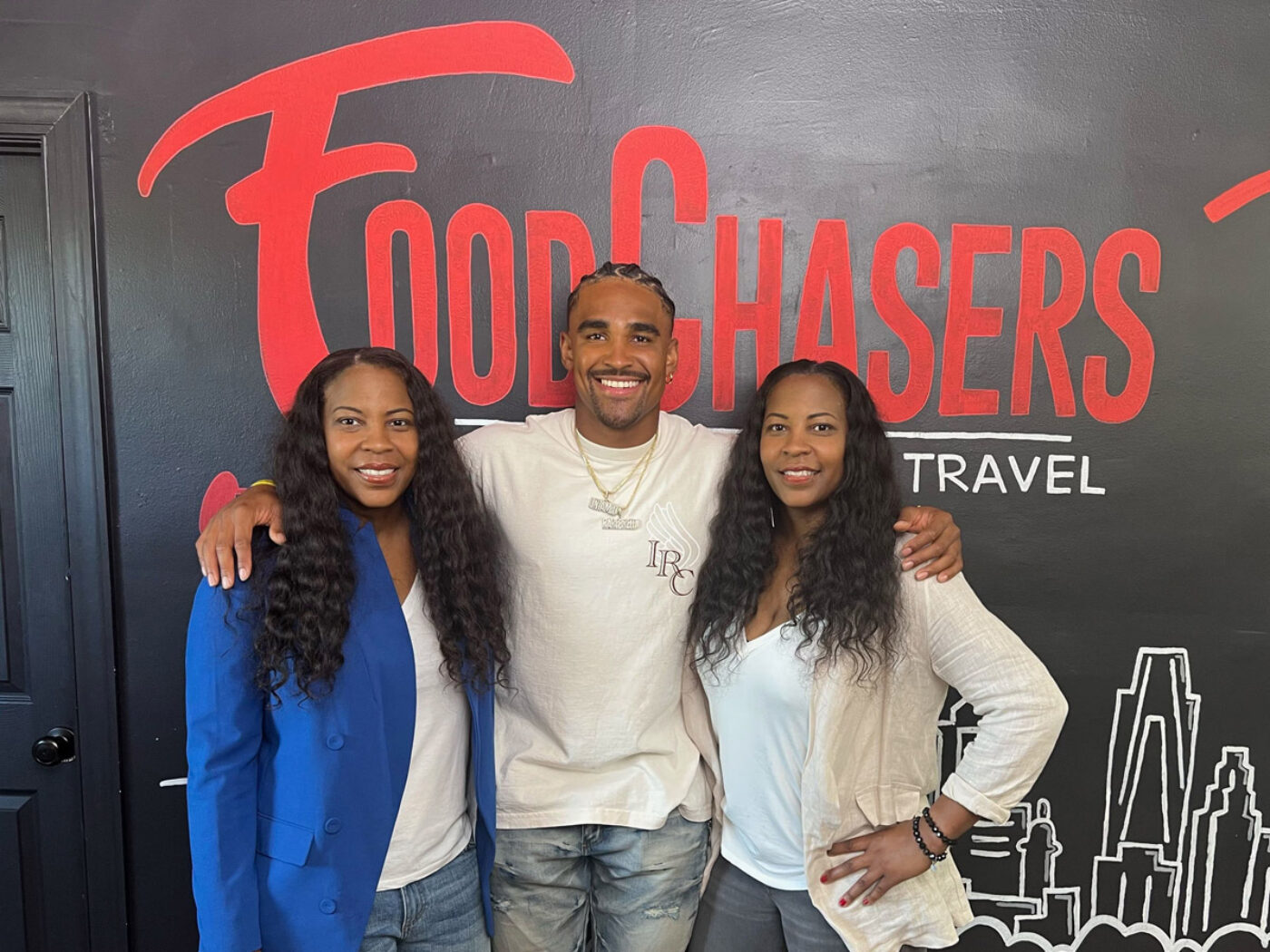 Jalen Hurts con los propietarios de FoodChasers' Kitchen