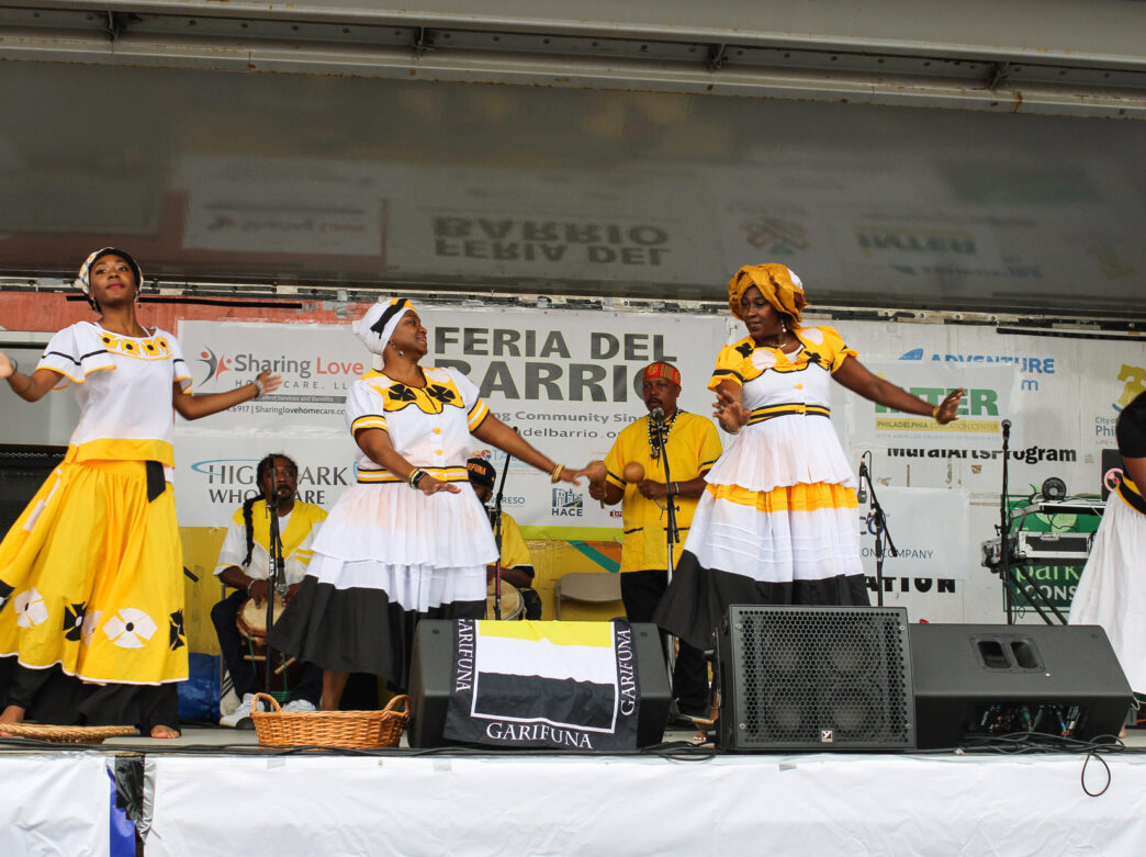 Group performing on stage at Feria del Barrio