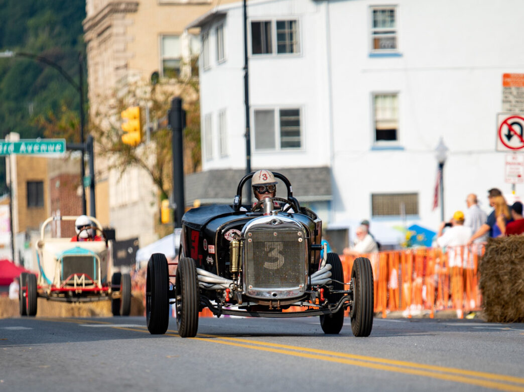 People driving hot rod cars