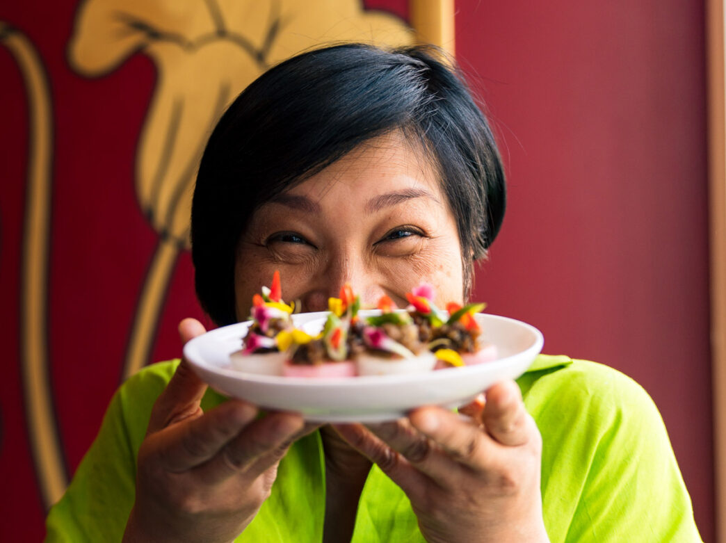 Chutatip “ Nok ” Suntaranon, du restaurant Kalaya Thai Kitchen, tient une assiette devant son visage.