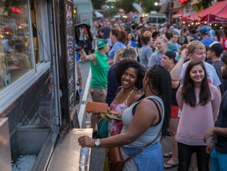 People wait to order from a food truck during a lively night market.