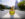 A person wearing a yellow top and jeans smiles while standing on a median on the Benjamin Franklin Parkway in Philadelphia