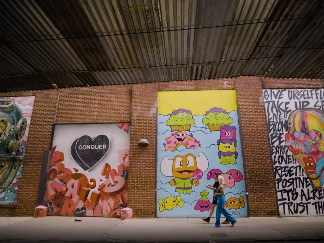 Two people walk by a series of murals on Front street between Columbia Avenue and Oxford Street in PHiladelphia during the 1st Look program