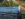 People walk along the Schuylkill River Trail while rowers during the Head of the Schuylkill Regatta row past in Philadelphia
