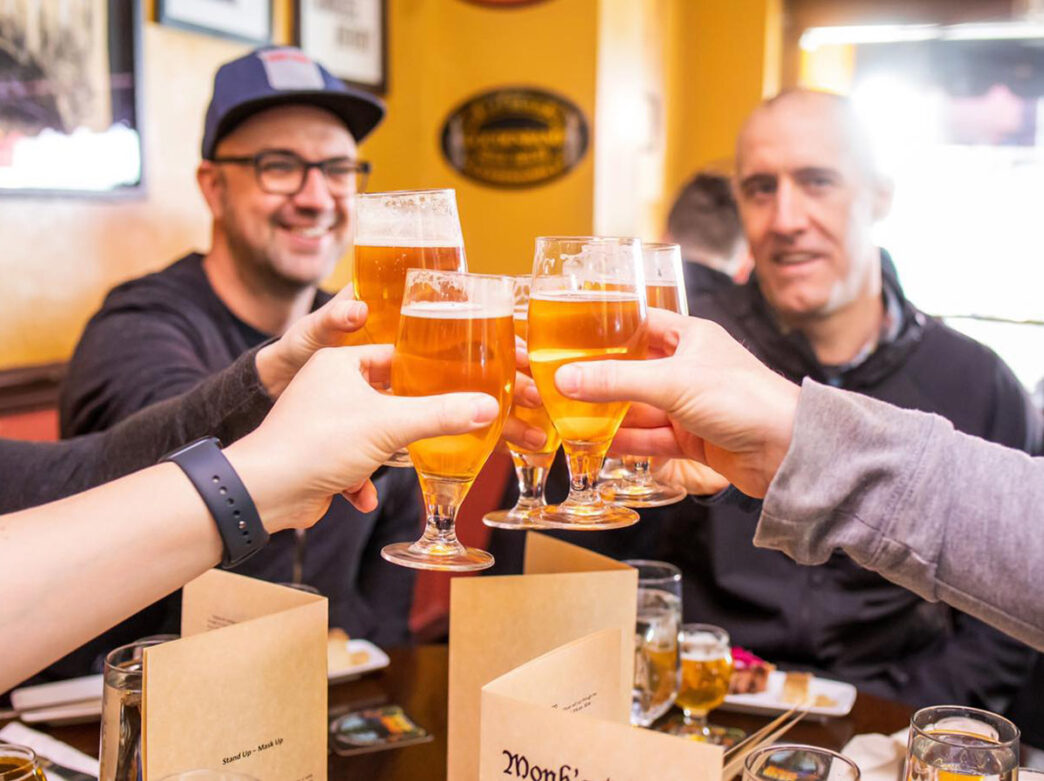 People doing a cheers at Monk's Cafe