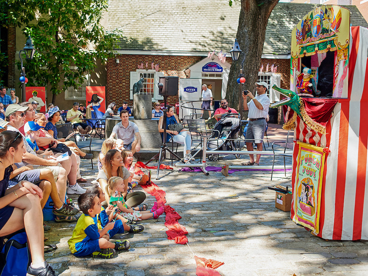 Families watching a puppet show at stars and stripes Saturday at the Betsy Ross House