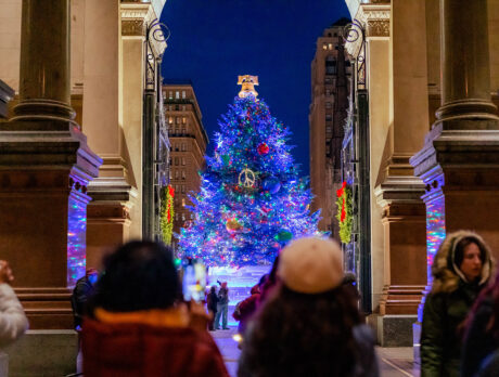 Children stand in the foreground while the VIsit Philadelphia Holiday Tree glows in the background