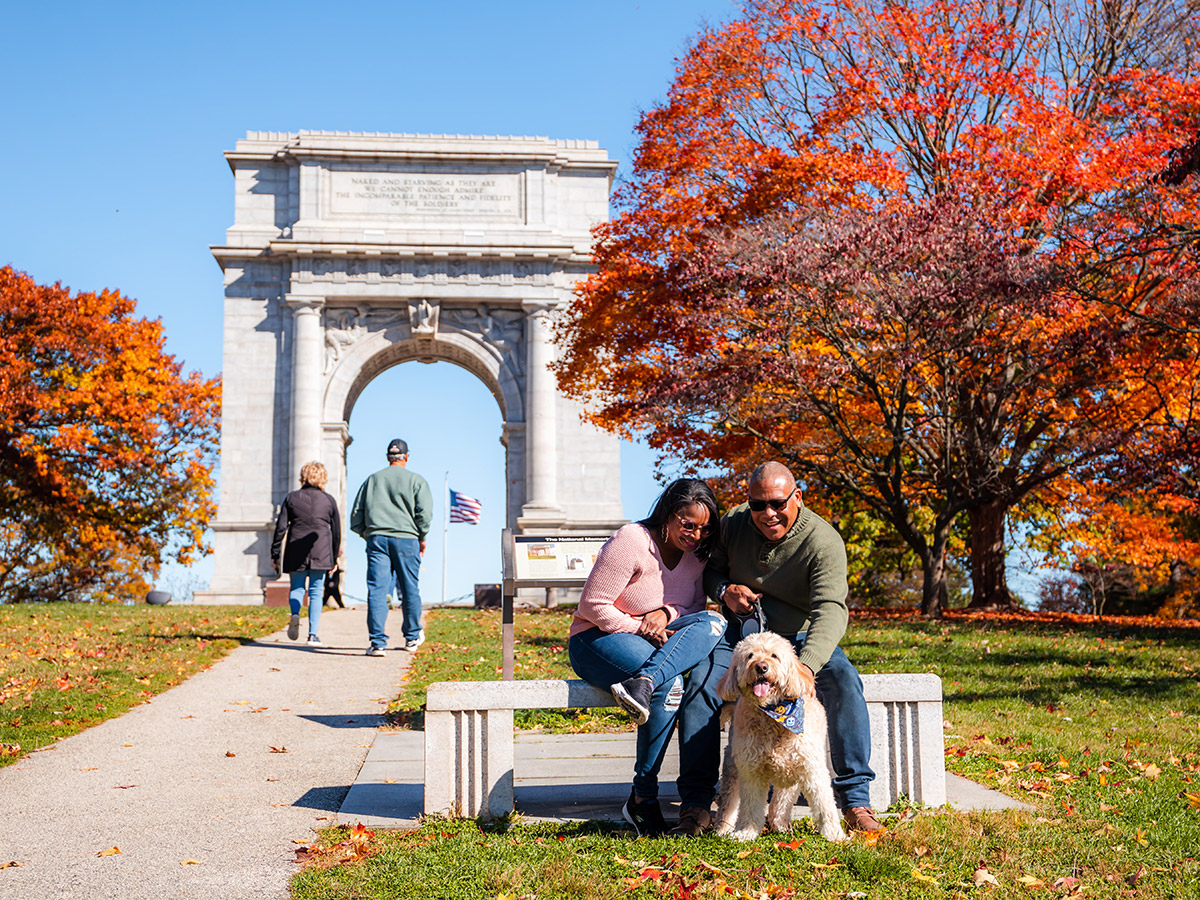 People and a dog at the Valley Forge National Historic Park monument
