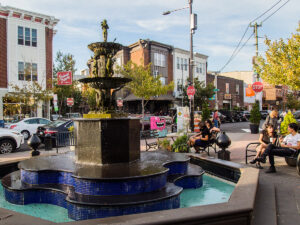 People sitting near the singing fountain in East Passyunk in South Philly