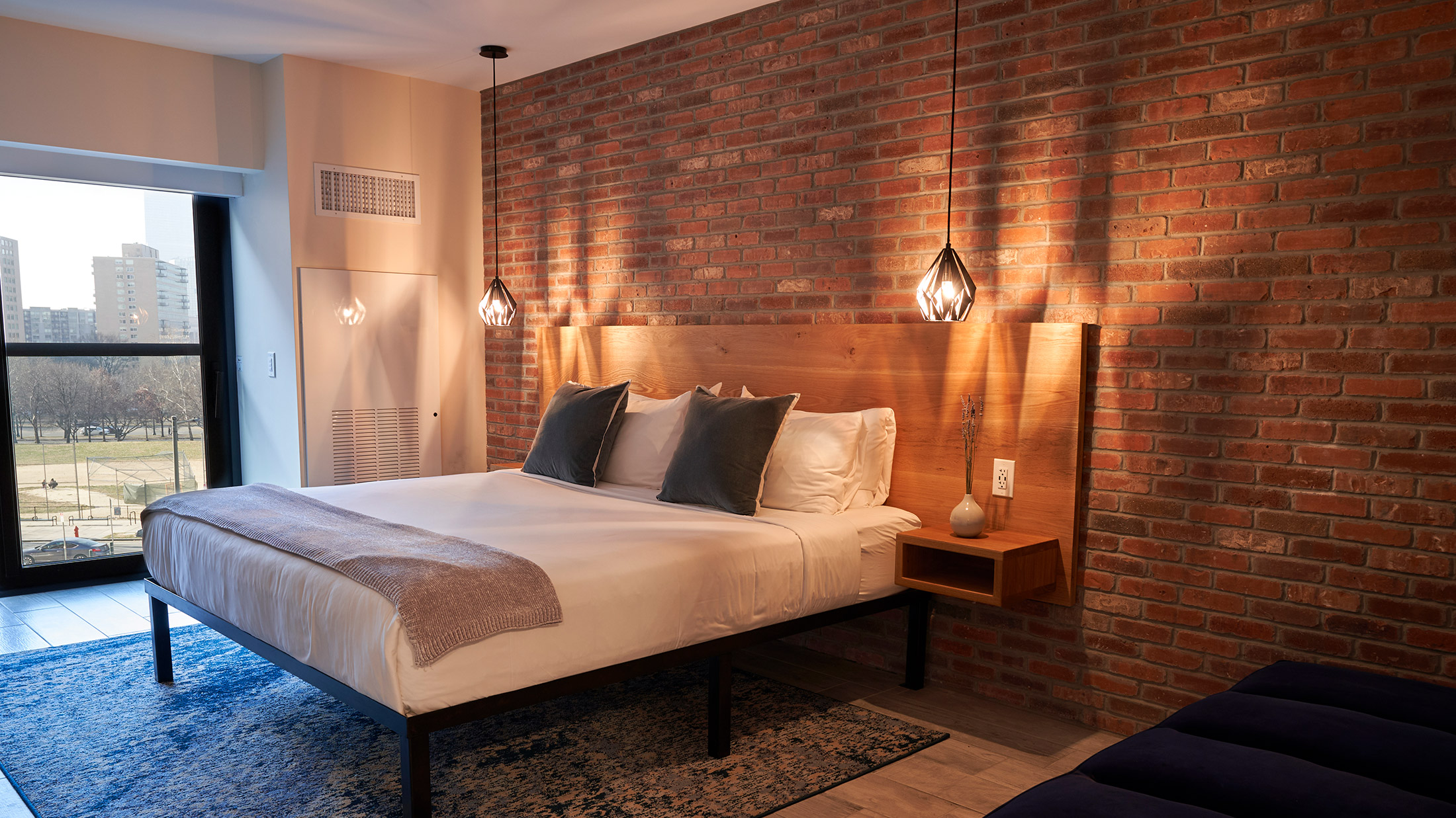 A bed against a brick wall at The Maj in Philadelphia