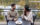 Couple drinking wine at a round table on the deck at River House at Odette's. View is overlooking Delaware River during fall.