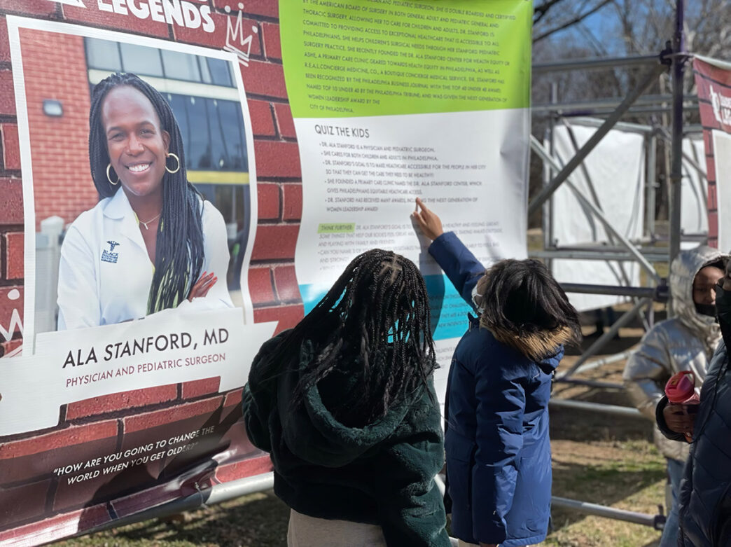 Kids reading a display of a Black Philadelphia leader at Smith Memorial Playground's Leaders and Legends program