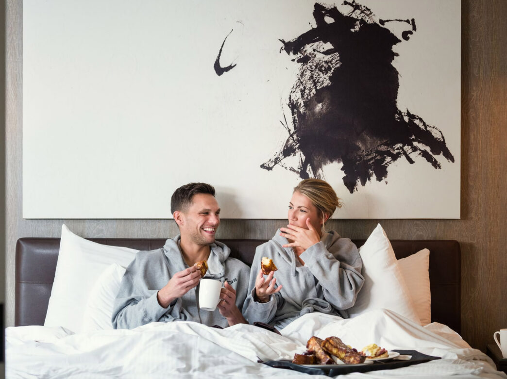 Couple eating breakfast in bed at The Logan
