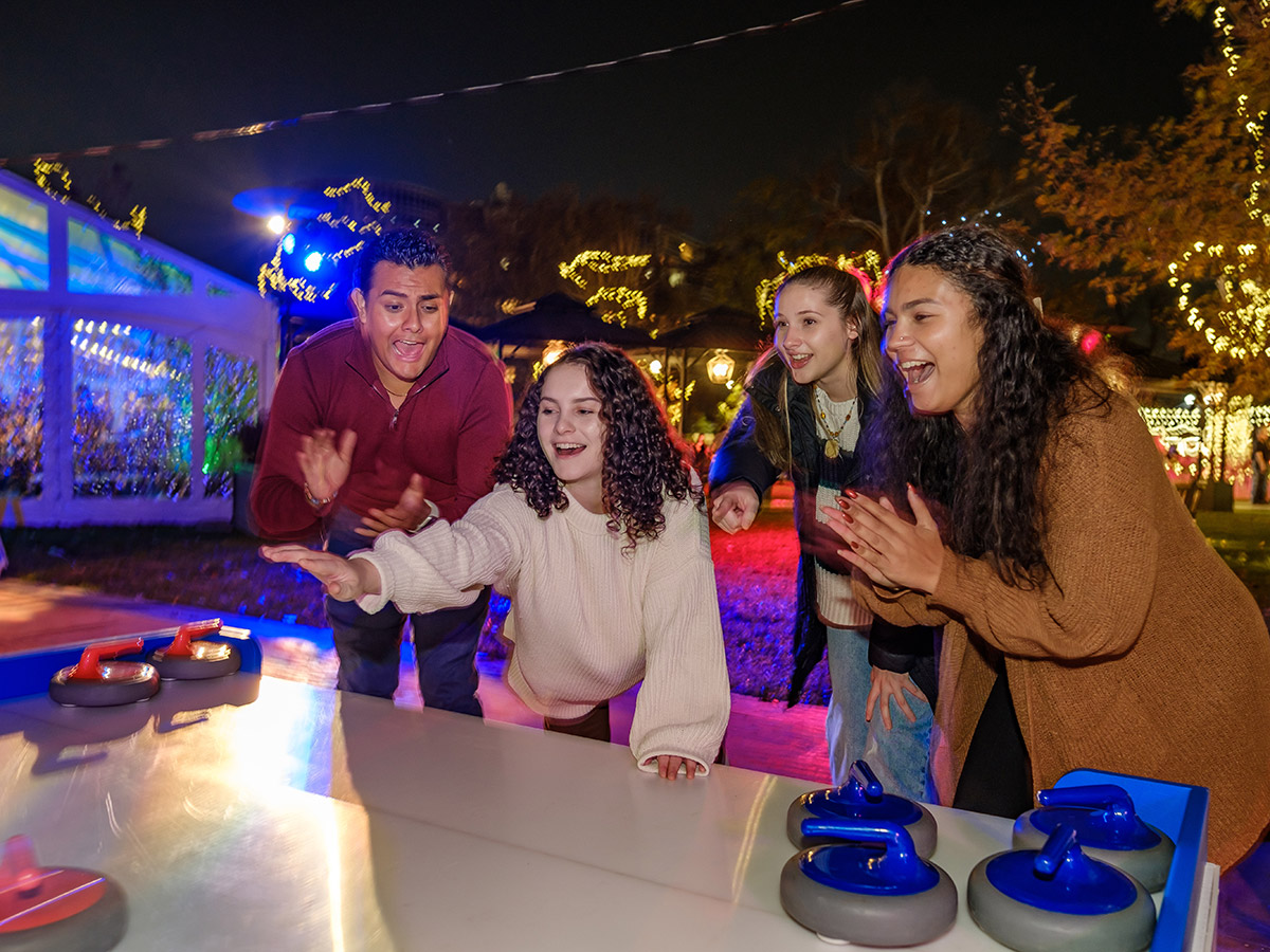 Group of young people happily tabletop curling at Franklin Square Park.