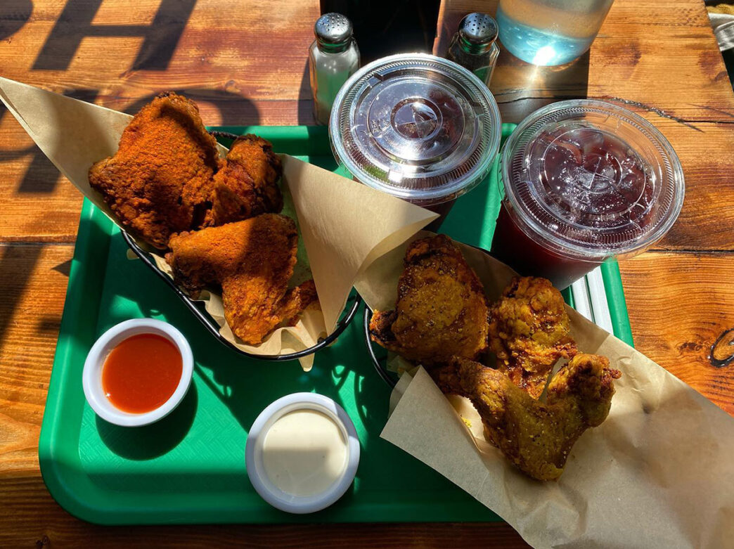 A tray of fried chicken served alongside dipping sauces and two soft drinks at Doro Bet.