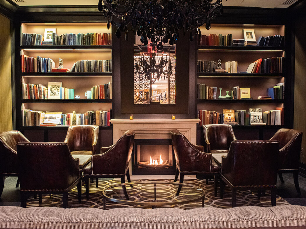 Lounge with fireplace, bookshelves and seating areas at the Library Bar in The Rittenhouse hotel in Philadelphia.