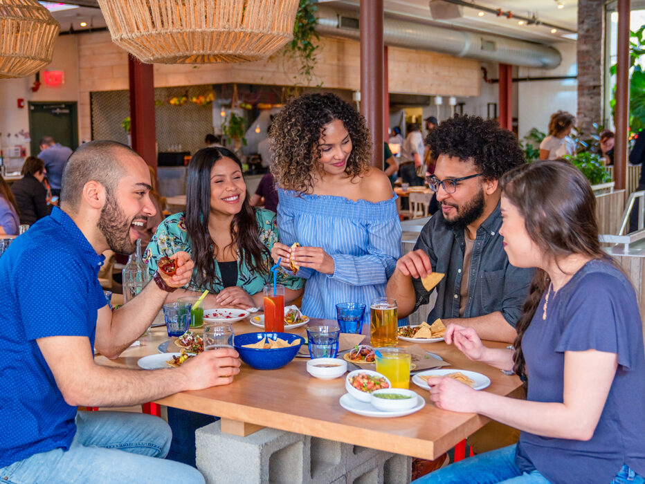 Un groupe de 5 personnes dîne et boit ensemble à Mission Taqueria à Philadelphie.