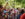 People walk in the Philadelphia Pride March while holding rainbow flags.