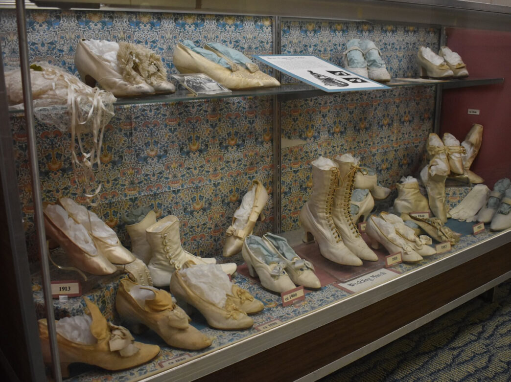 Collection of bridal shoes from the 1900s are displayed in a glass cabinet at The Shoe Museum at Temple University's School of Podiatric Medicine in Philadelphia.