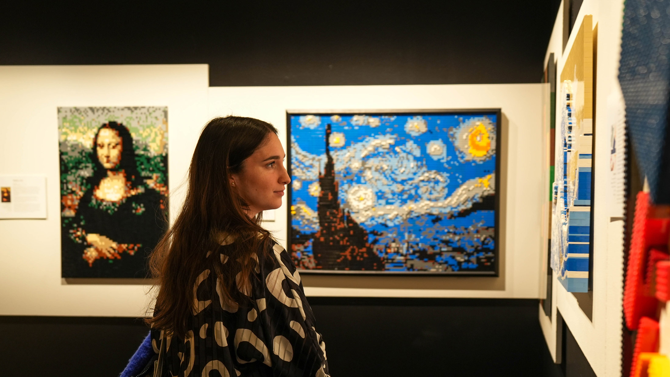 Woman looking at LEGO recreations of classic art at The Art of the Brick at The Franklin Institute