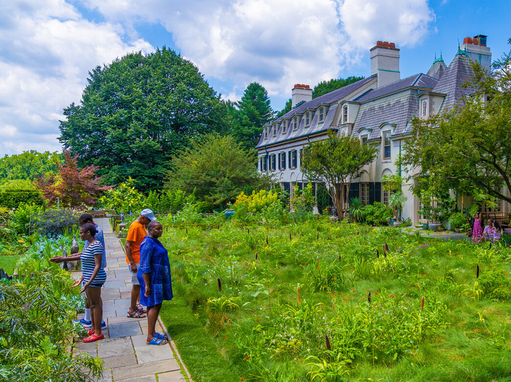 Una familia camina por un sendero de piedra a través de los jardines en Chanticleer.