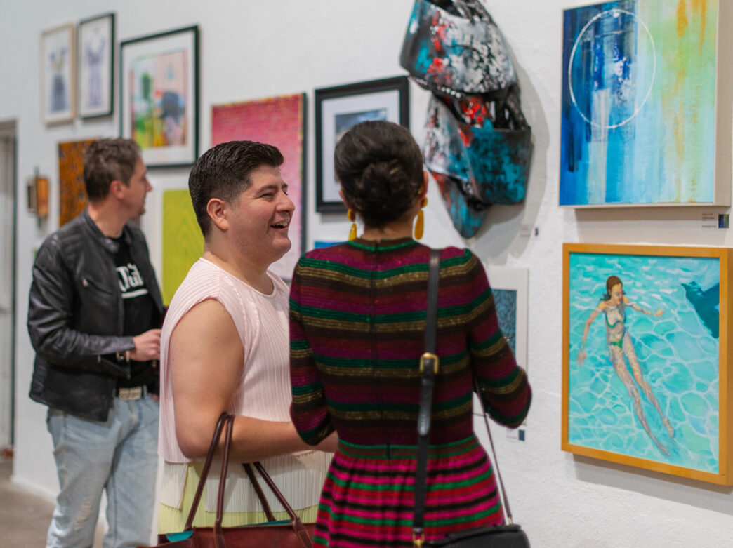 Three people admire artwork displayed at InLiquid Gallery in Philadelphia.
