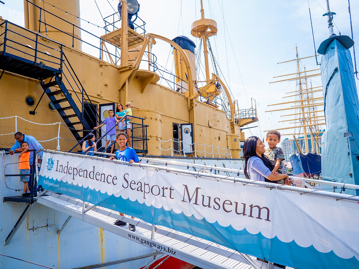 Guests of all ages explore the Olympia, a 19th-century cruiser docked outside of the Independence Seaport Museum.