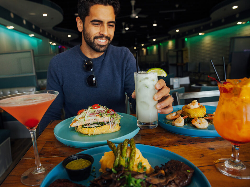 Una persona sentada a la mesa disfrutando de una comida y bebidas en Izlas, en Filadelfia.