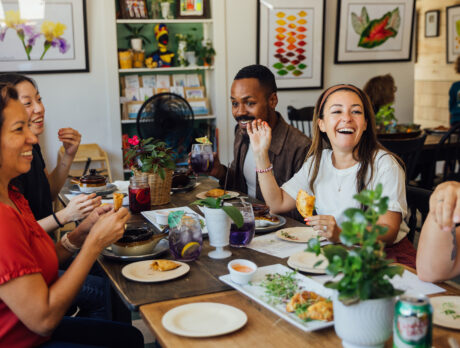 A group of five people eat Colombian empanadas and drink purple drinks at a rectangular table at Margie's Cuisine in Chadds Ford, PA.