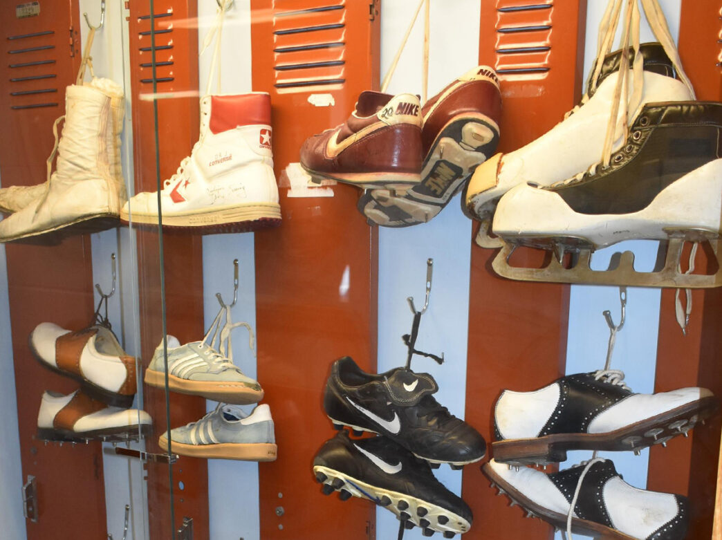 Collection of athletic shoes are hung from metal lockers in a glass cabinet at The Shoe Museum at Temple University's School of Podiatric Medicine in Philadelphia.