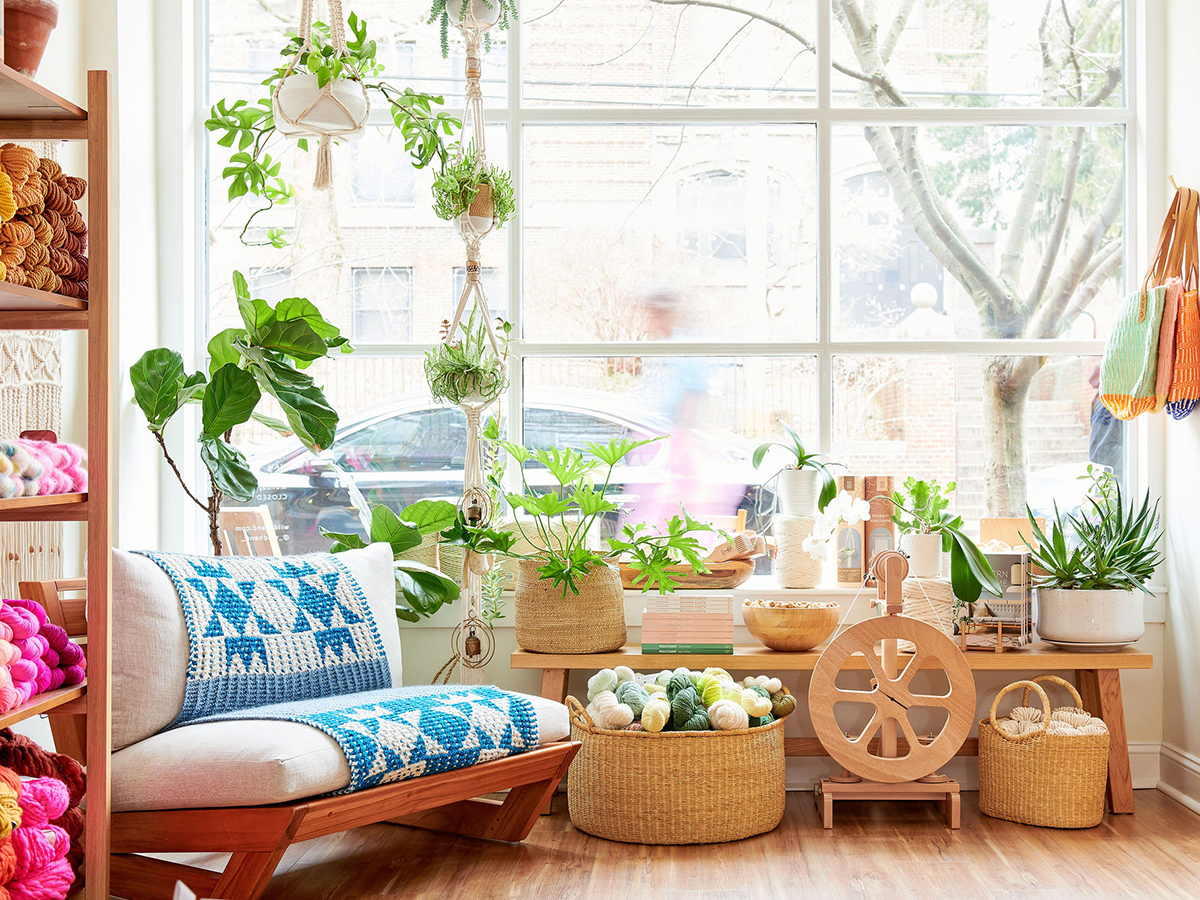 Interior of Wild Hand yarn shop in Philadelphia with skeins of colorful yarn in baskets and on shelves.