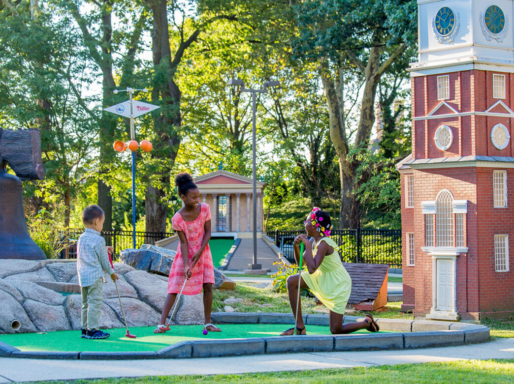 Three kids play mini golf in Franklin Square during the summer months.