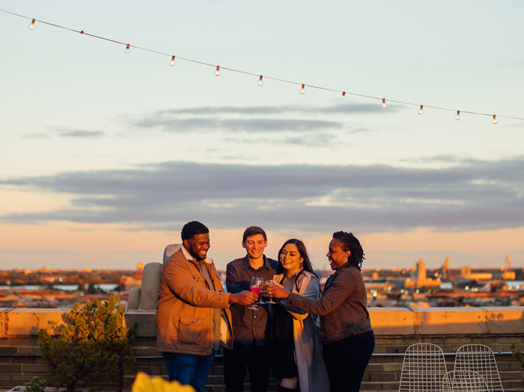People having drinks on the rooftop deck of Irwin's at sunset in Philadelphia.