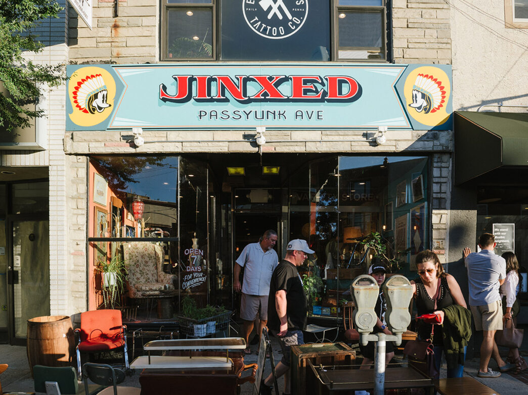 Several shoppers browse the vintage home decor and furniture displayed outside of Jinxed on Passyunk Ave.