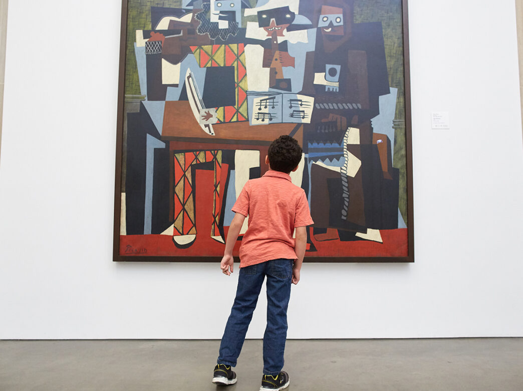 A kid looks up at a painting while visiting the Philadelphia Museum of Art.