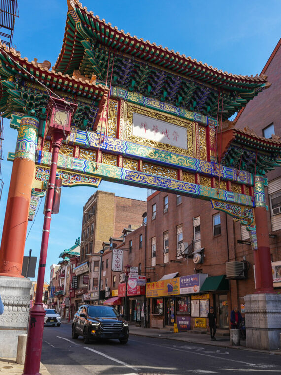 People walking on the sidewalk through Chinatown near the Friendship Gate