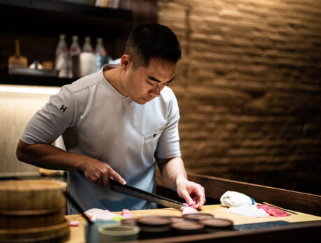 Chef Jesse Ito prepares sushi while wearing a white chef shirt at his restaurant Royal Sushi and Izakaya in Philadelphia.