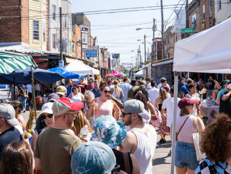 A crowd of casually dressed festival-goers enjoy food and drink from vendors on Ninth Street during the 9th Street Italian Market Festival.